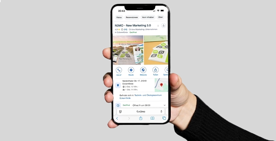 Eine Hand hält ein Smartphone, auf dessen Bildschirm das Google-Unternehmensprofil zu sehen ist.