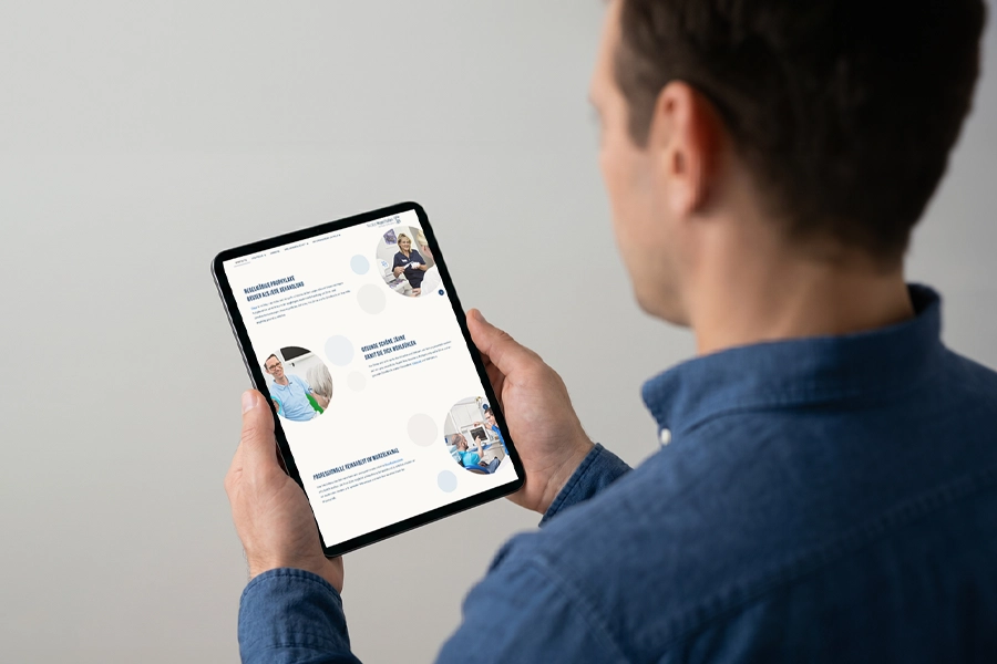 Ein Zahnarzt betrachtet seine eigene Website auf seinem Tablet.